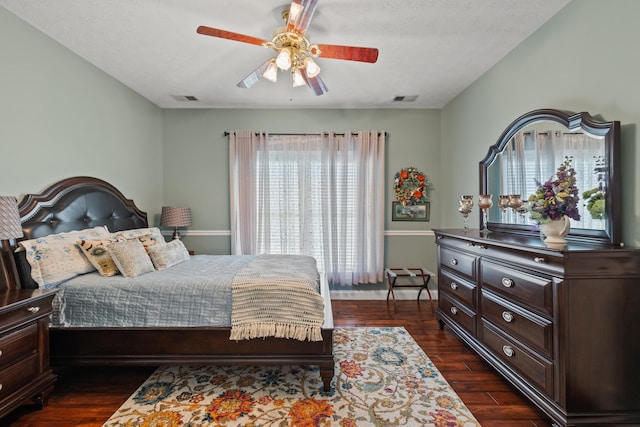 bedroom with ceiling fan, dark hardwood / wood-style floors, and a textured ceiling