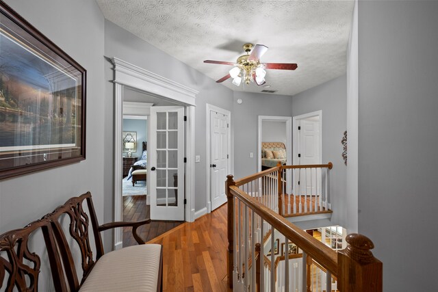 hallway featuring hardwood / wood-style floors and a textured ceiling