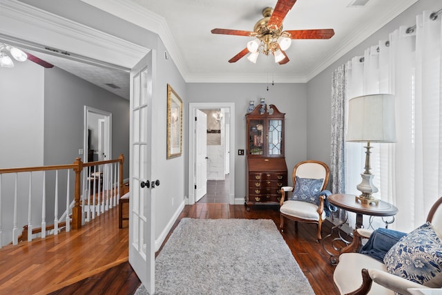 sitting room featuring dark hardwood / wood-style floors, crown molding, and ceiling fan