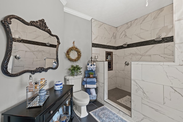 bathroom with toilet, a tile shower, and crown molding