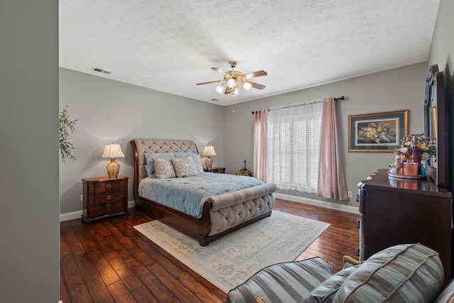 bedroom with ceiling fan, a textured ceiling, and dark hardwood / wood-style flooring