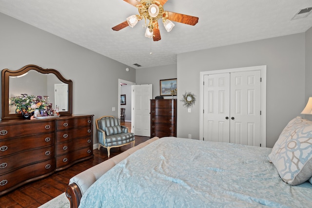 bedroom featuring ceiling fan, a textured ceiling, a closet, and dark hardwood / wood-style flooring