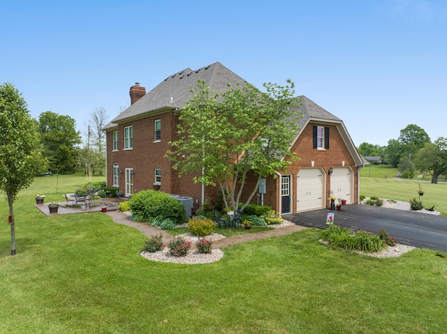 view of front of property with a patio area, a garage, central AC, and a front lawn