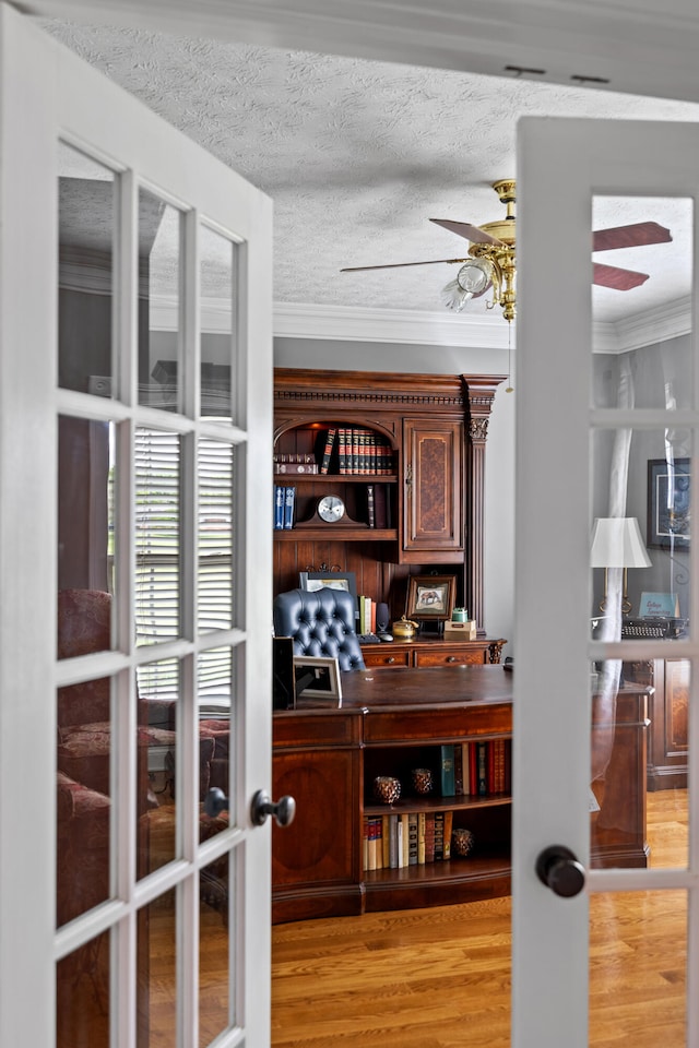 interior space with french doors, a textured ceiling, ceiling fan, crown molding, and light hardwood / wood-style flooring