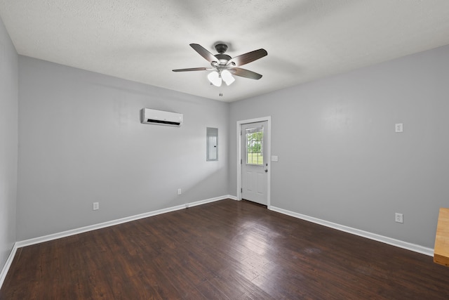 unfurnished room featuring electric panel, dark wood-type flooring, a textured ceiling, ceiling fan, and an AC wall unit