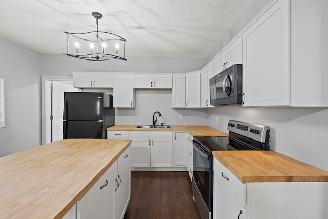 kitchen with black appliances, wooden counters, pendant lighting, sink, and white cabinets