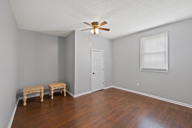 spare room featuring dark hardwood / wood-style flooring, a textured ceiling, and ceiling fan