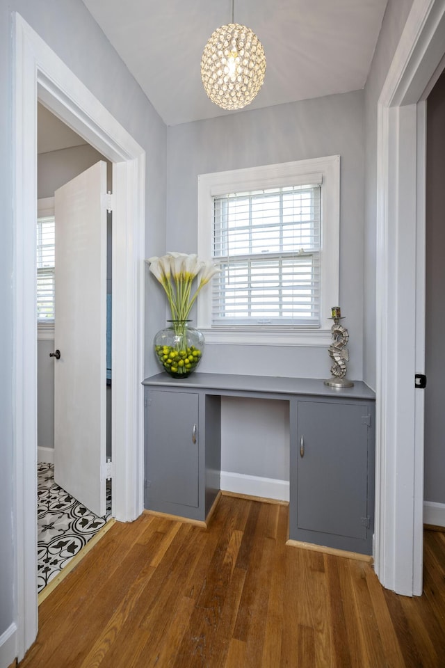 hallway with dark hardwood / wood-style flooring and an inviting chandelier