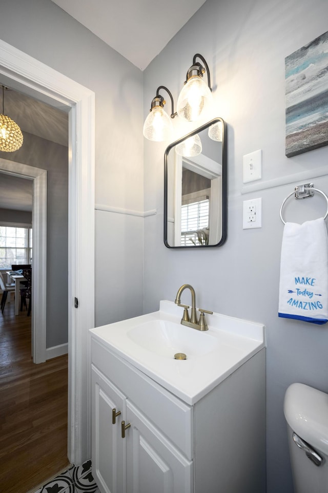 bathroom with hardwood / wood-style floors, vanity, and toilet