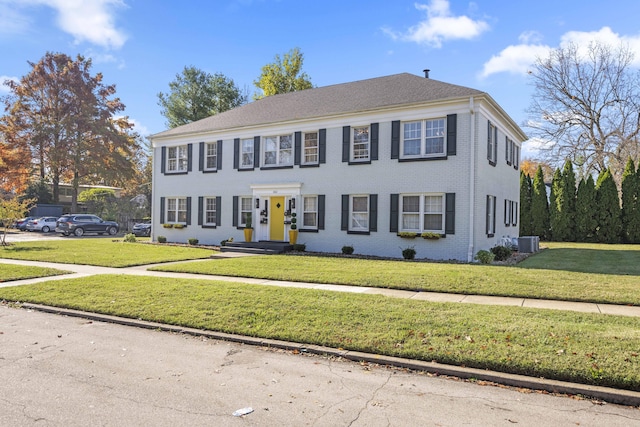 colonial home featuring a front yard and central AC unit