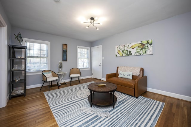 living room featuring an inviting chandelier and dark wood-type flooring