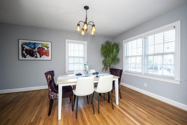 dining room with hardwood / wood-style flooring, an inviting chandelier, and plenty of natural light