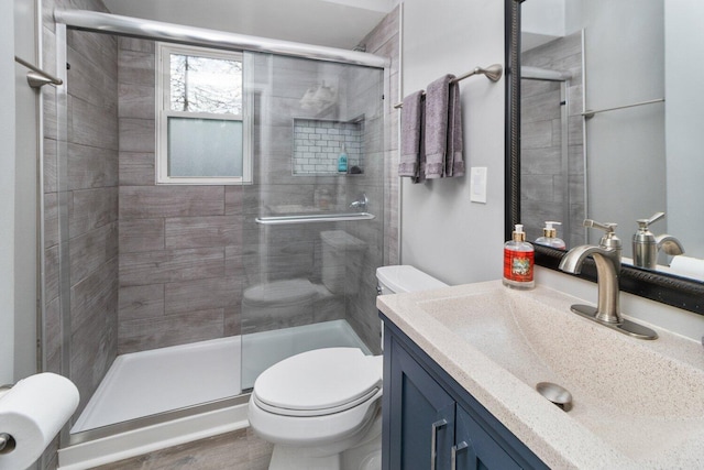 bathroom featuring an enclosed shower, vanity, toilet, and wood-type flooring