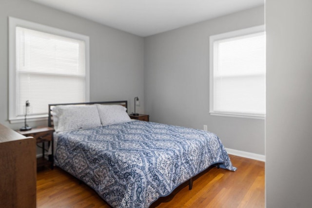 bedroom with hardwood / wood-style flooring and multiple windows