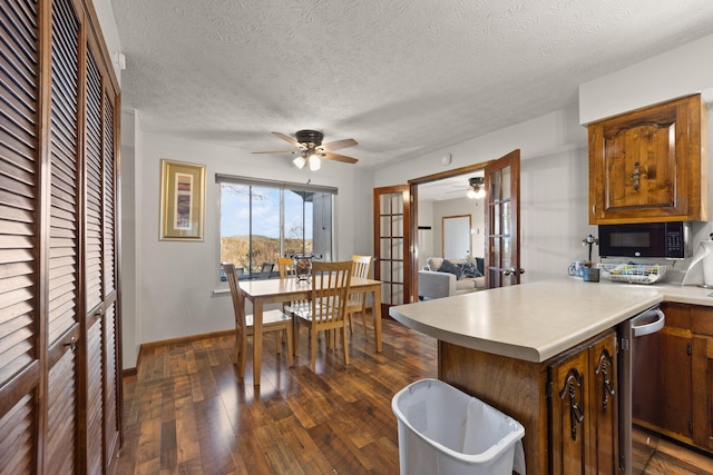 kitchen featuring dishwasher, french doors, a textured ceiling, and dark hardwood / wood-style floors