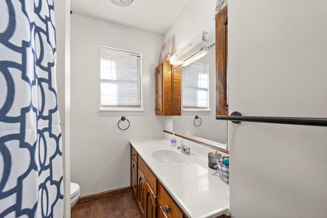 bathroom featuring hardwood / wood-style floors, vanity, toilet, and walk in shower