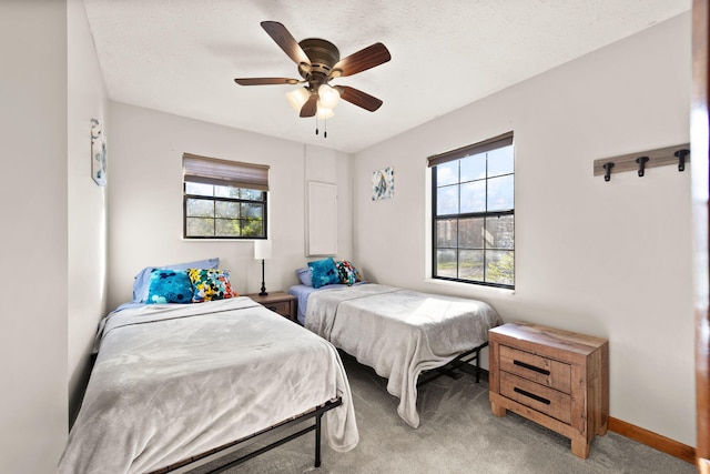 bedroom with a textured ceiling, ceiling fan, light carpet, and multiple windows