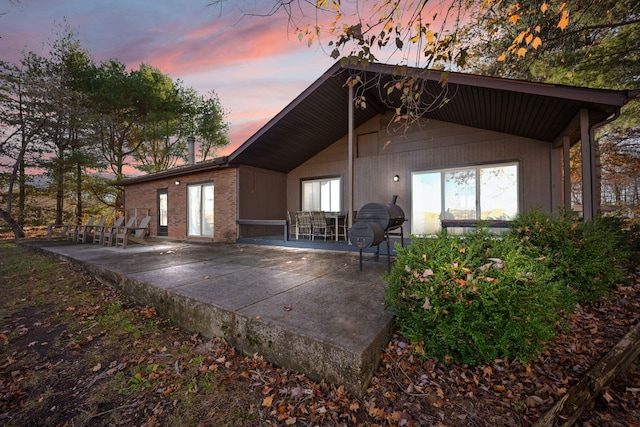 back house at dusk with a patio