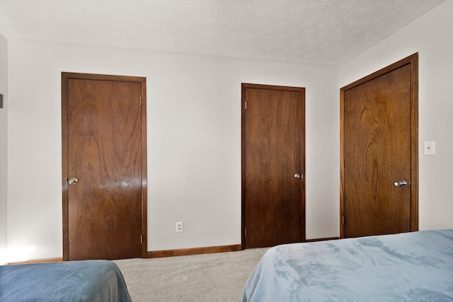 carpeted bedroom with a textured ceiling and a closet