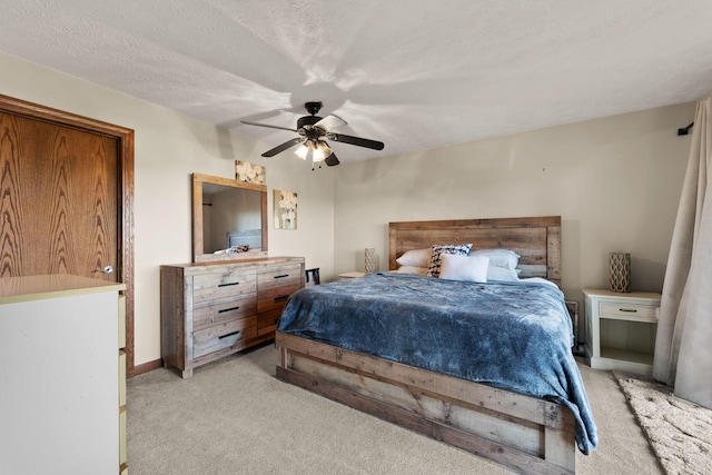 carpeted bedroom with ceiling fan and a textured ceiling