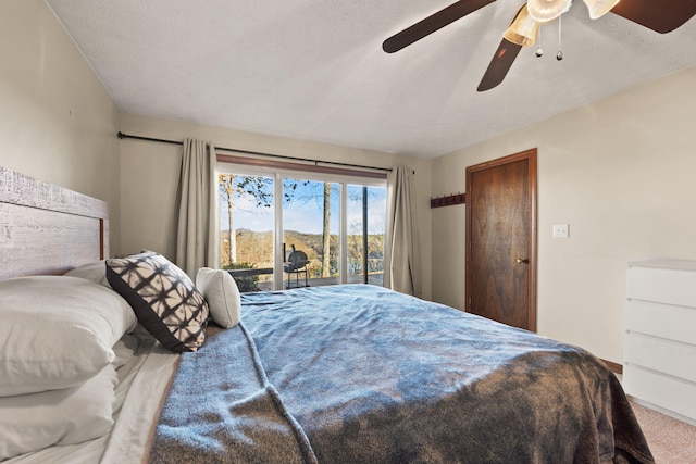 carpeted bedroom with access to exterior, a textured ceiling, and ceiling fan