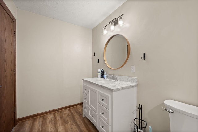 bathroom featuring hardwood / wood-style floors, vanity, a textured ceiling, and toilet