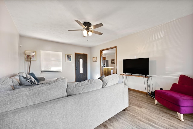 living room featuring light hardwood / wood-style flooring and ceiling fan