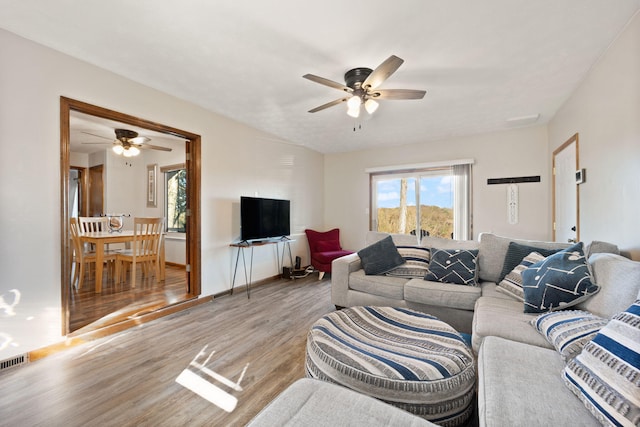 living room with ceiling fan and light hardwood / wood-style flooring