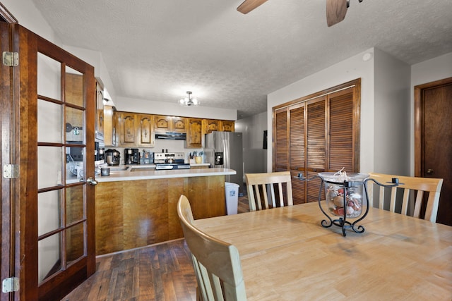 dining area featuring a textured ceiling, ceiling fan, and dark wood-type flooring