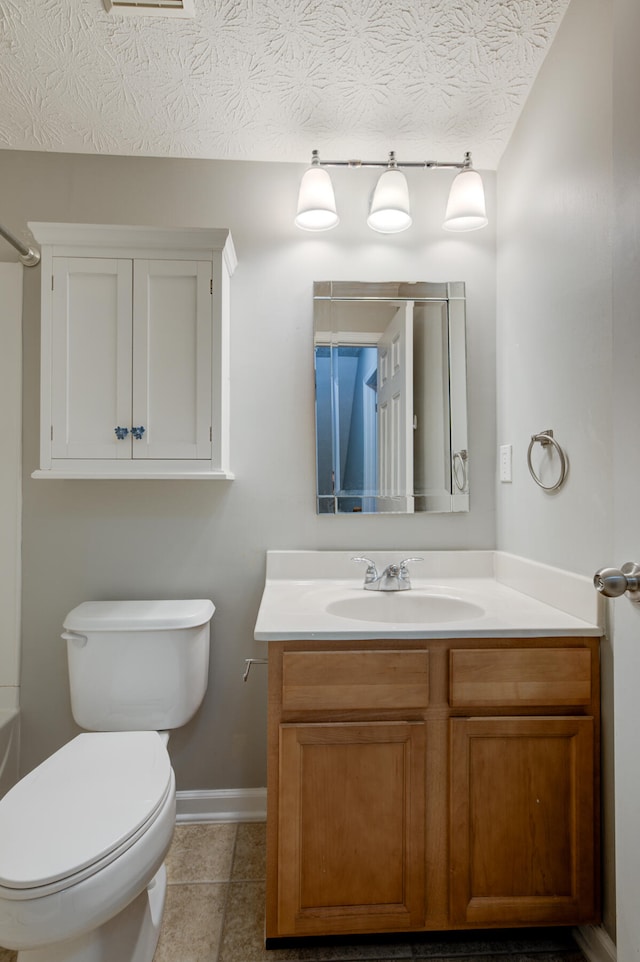 bathroom featuring tile patterned flooring, vanity, a textured ceiling, and toilet