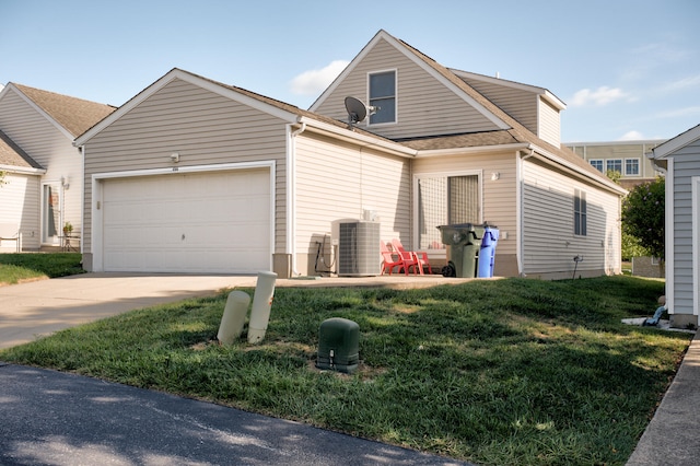 view of front of property with central air condition unit, a front yard, and a garage