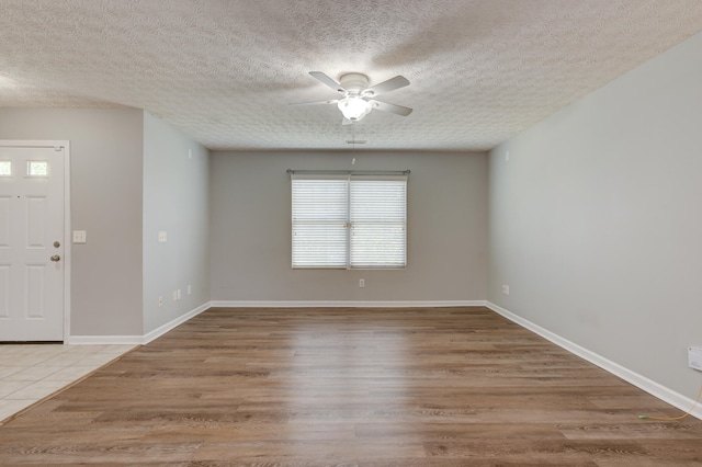 spare room with hardwood / wood-style floors, a textured ceiling, and a wealth of natural light