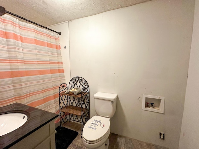 bathroom with vanity, a textured ceiling, and toilet