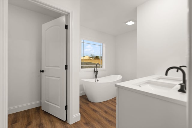 bathroom with a bathtub, vanity, and hardwood / wood-style flooring