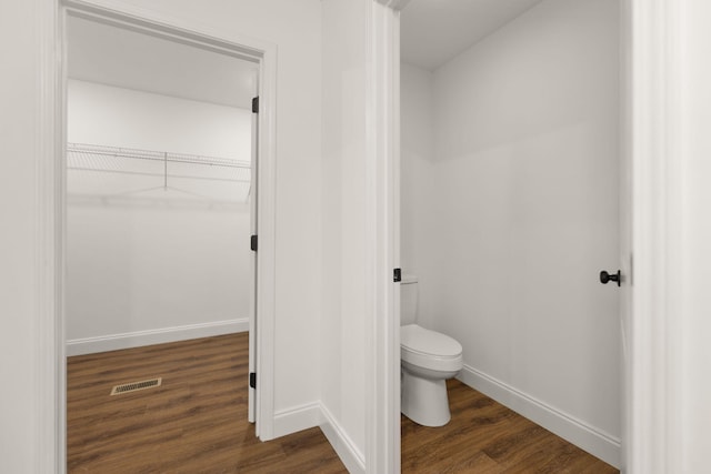 bathroom featuring toilet and wood-type flooring