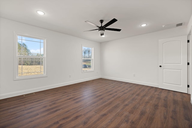 unfurnished room with dark hardwood / wood-style flooring, a wealth of natural light, and ceiling fan