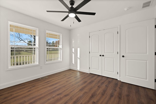 unfurnished bedroom featuring a closet, ceiling fan, and dark hardwood / wood-style flooring