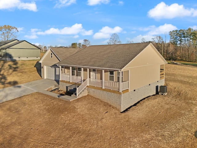 view of front of house with covered porch, a garage, and central AC unit