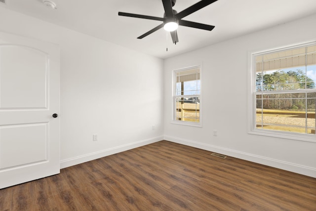 spare room featuring plenty of natural light, dark hardwood / wood-style floors, and ceiling fan