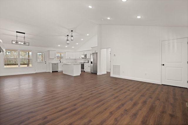 unfurnished living room featuring dark hardwood / wood-style flooring, sink, and high vaulted ceiling