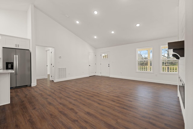 unfurnished living room with dark hardwood / wood-style flooring and high vaulted ceiling