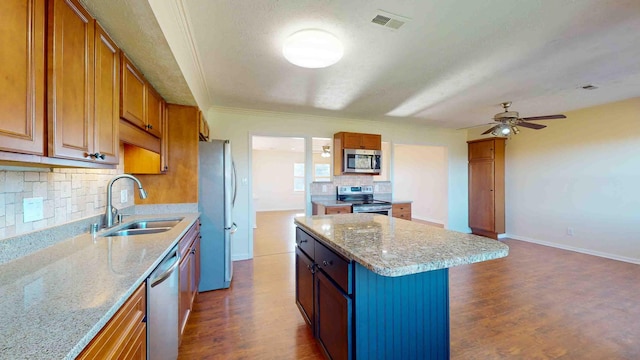 kitchen featuring stainless steel appliances, dark hardwood / wood-style floors, a center island, and sink