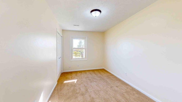 carpeted spare room with a textured ceiling