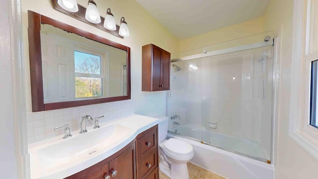 full bathroom featuring vanity, toilet, combined bath / shower with glass door, and decorative backsplash