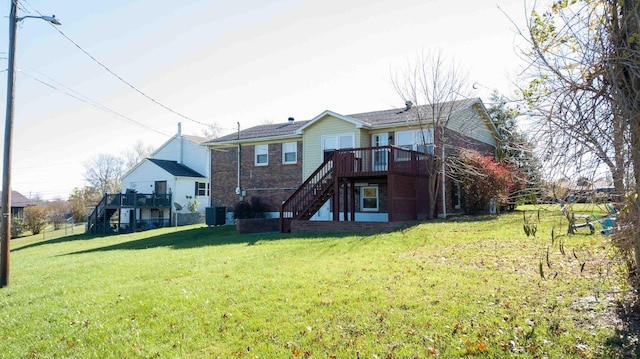 rear view of house with a wooden deck, central air condition unit, and a lawn