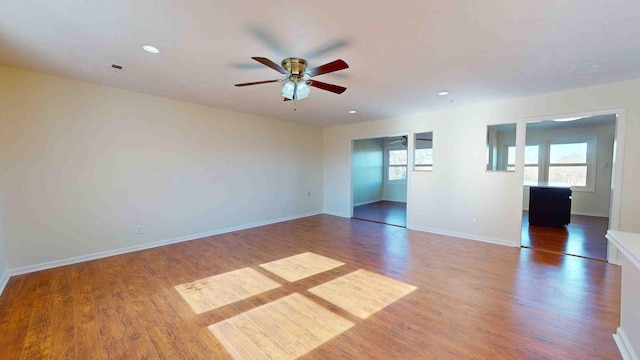 empty room with dark hardwood / wood-style floors and ceiling fan