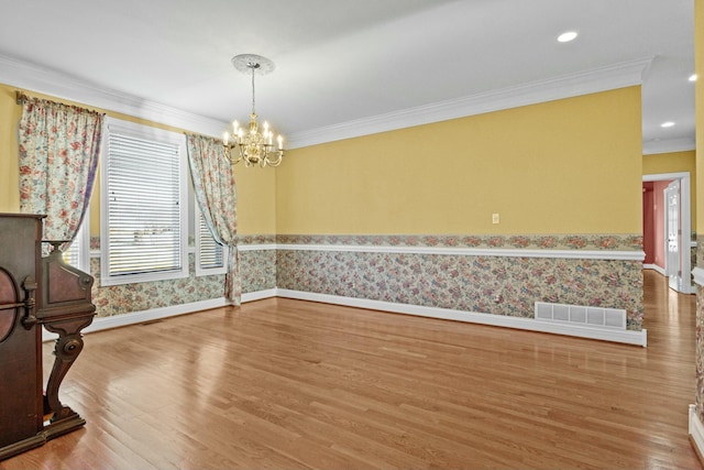 dining area featuring crown molding, hardwood / wood-style floors, and a chandelier