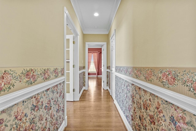 corridor with ornamental molding and light wood-type flooring