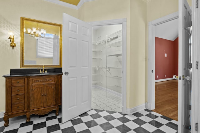 bathroom with vanity, a notable chandelier, and crown molding