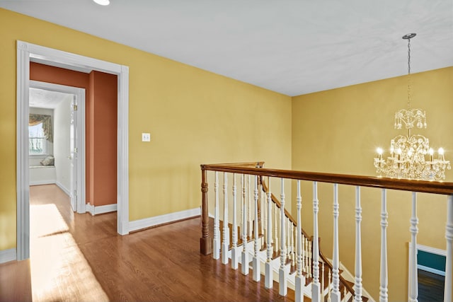 hallway featuring hardwood / wood-style flooring and a notable chandelier